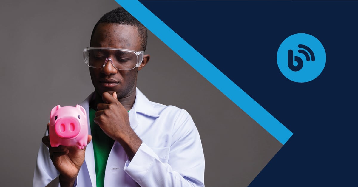 Young male scientist with safety glasses holding a piggy bank